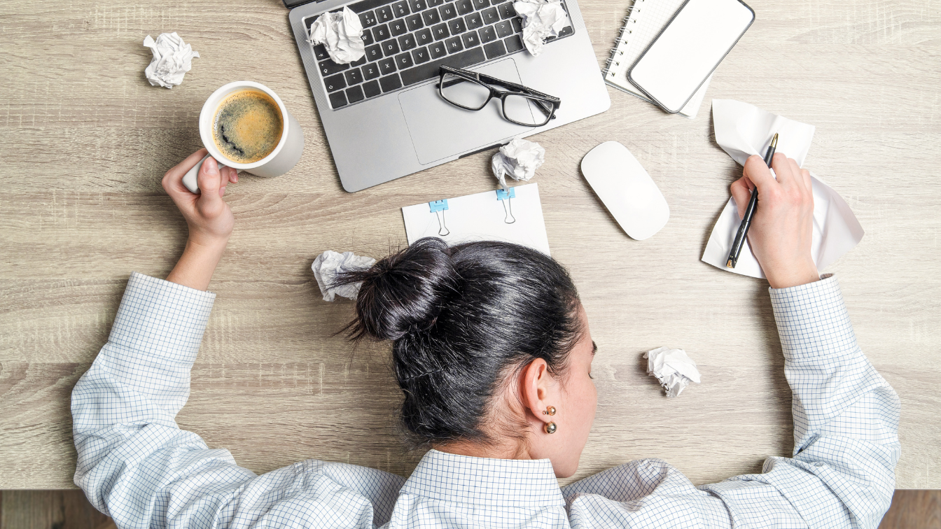 Image of a person tired at their work desk